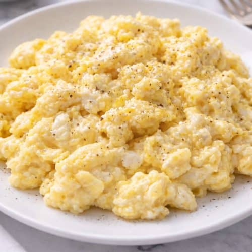 Carnivore cottage cheese scrambled eggs topped with a light sprinkle of black pepper on a white plate.