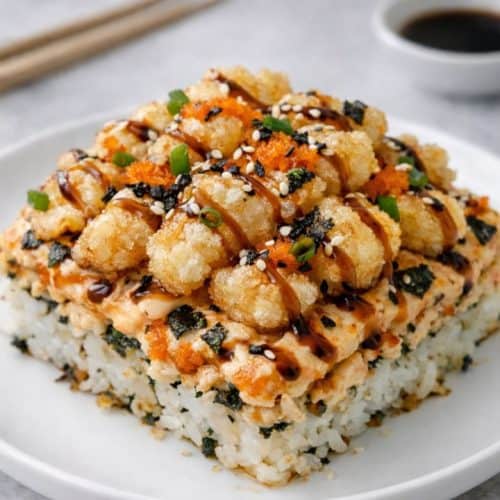 Shrimp tempura sushi bake square with crispy tempura, spicy mayo, and eel sauce on a white plate