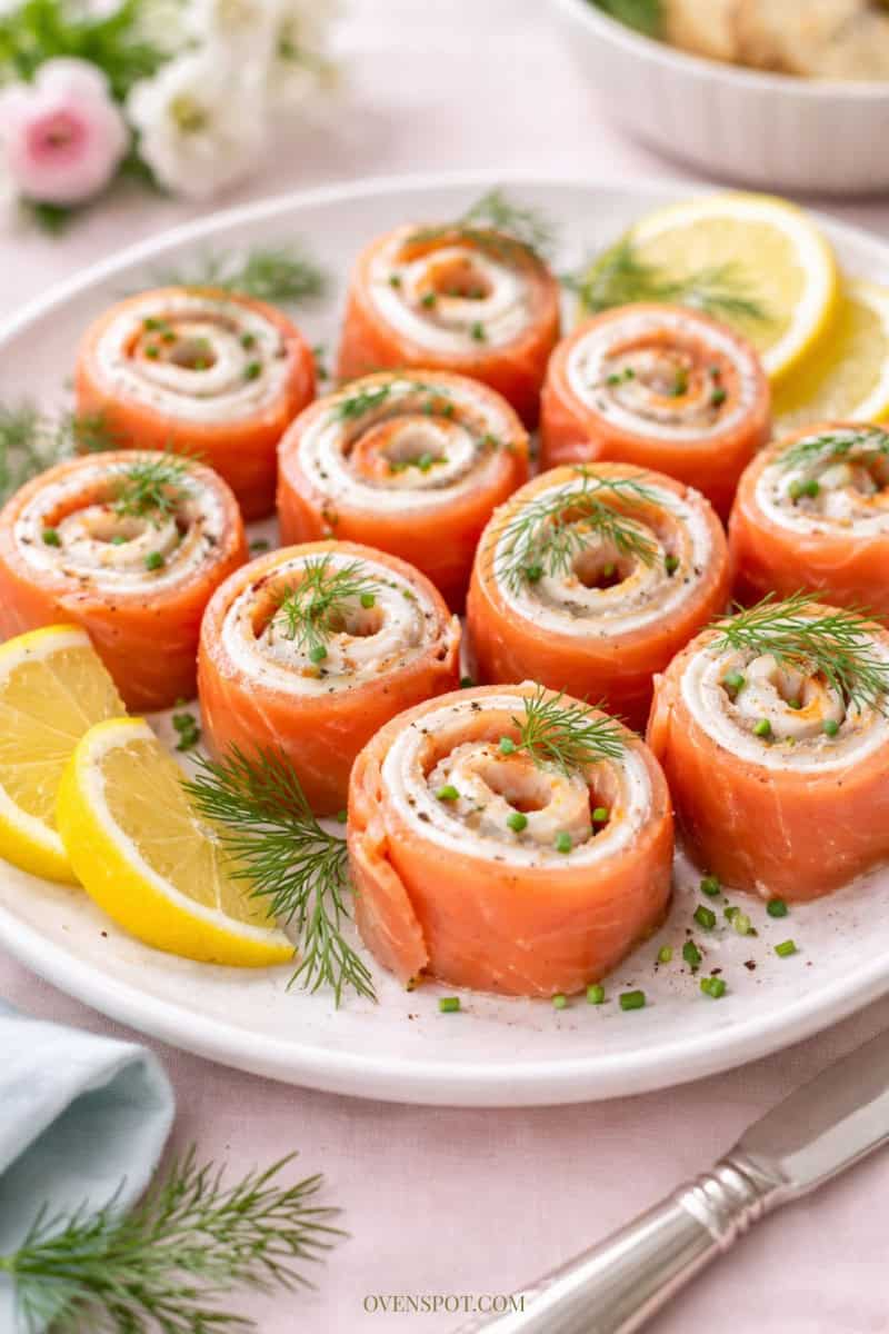 Smoked salmon and cream cheese roll-ups garnished with dill and lemon