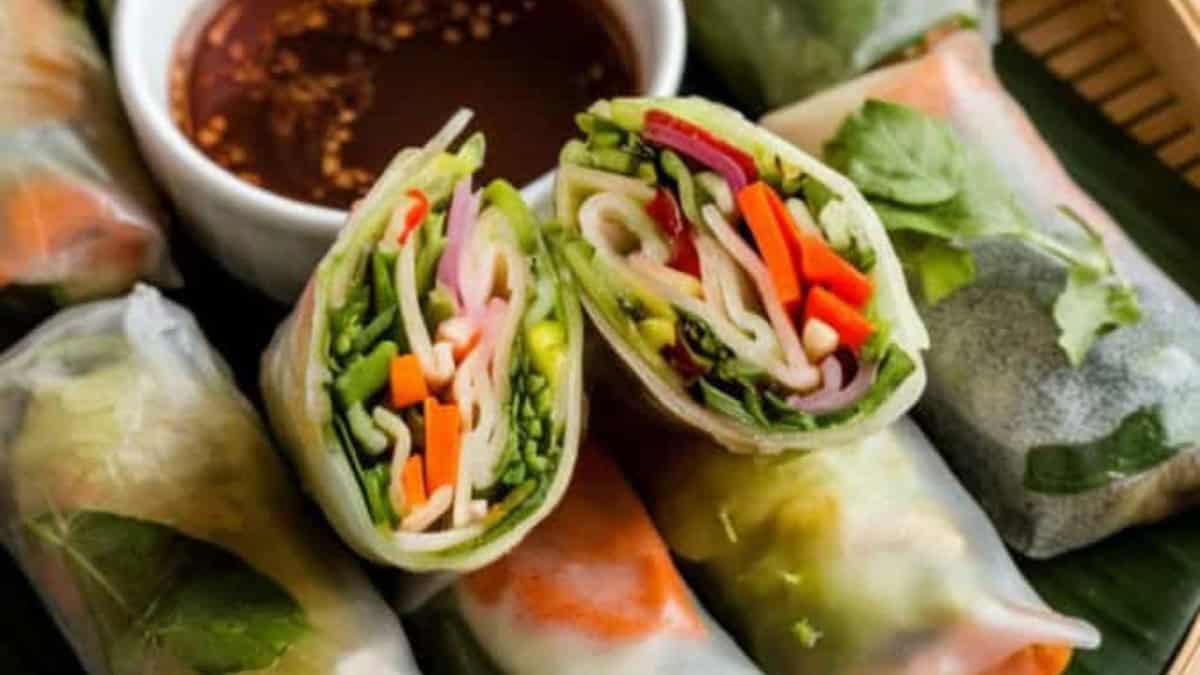 vegetable spring rolls on a white plate with lime soy sesame dipping sauce